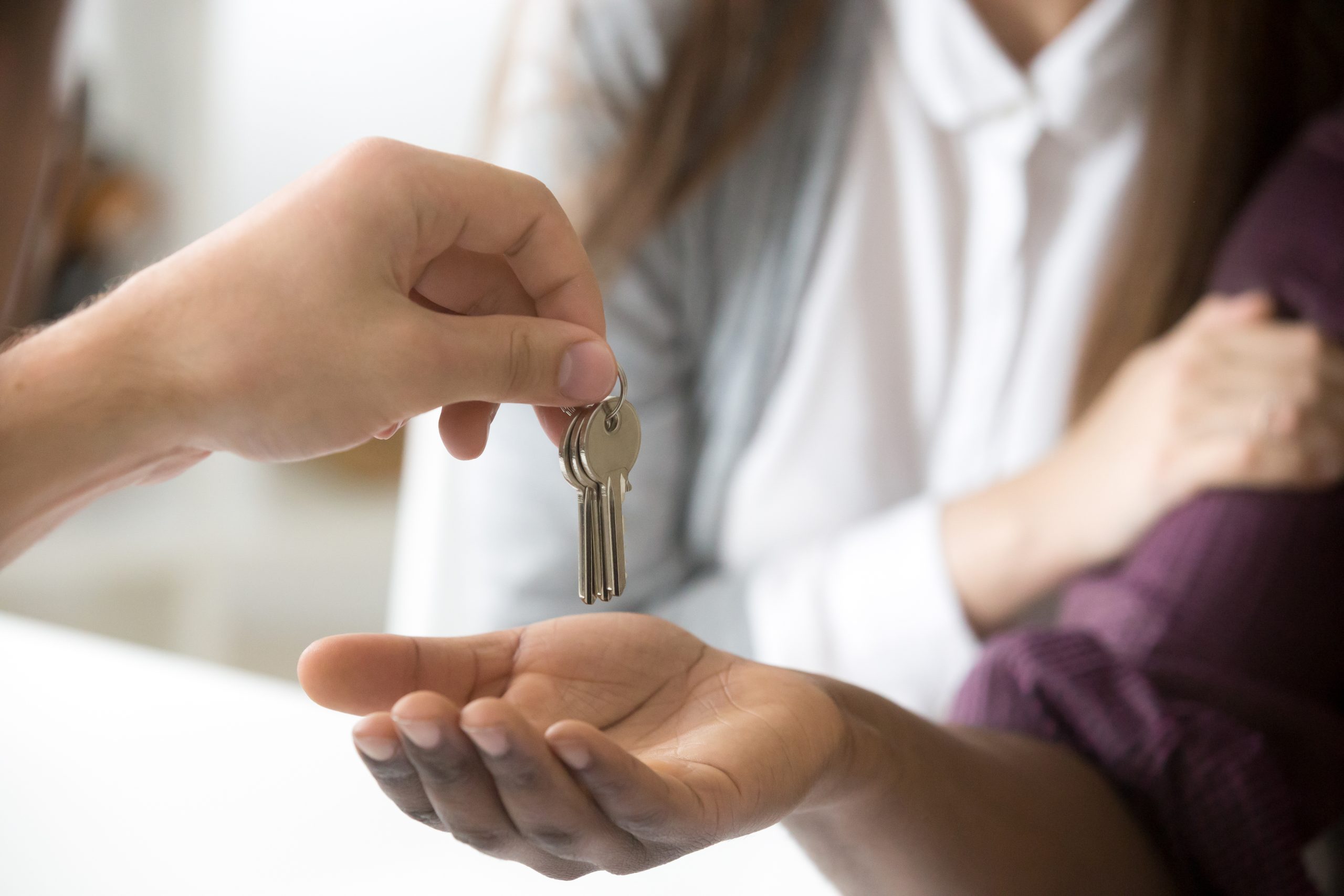 Realtor giving african customer keys, couple buying new house, c